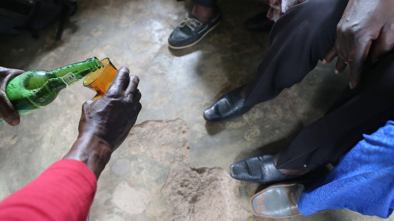 Männer trinken Bier in einem Dorf in Togo. Männer trinken Bier in einem Dorf in Togo.