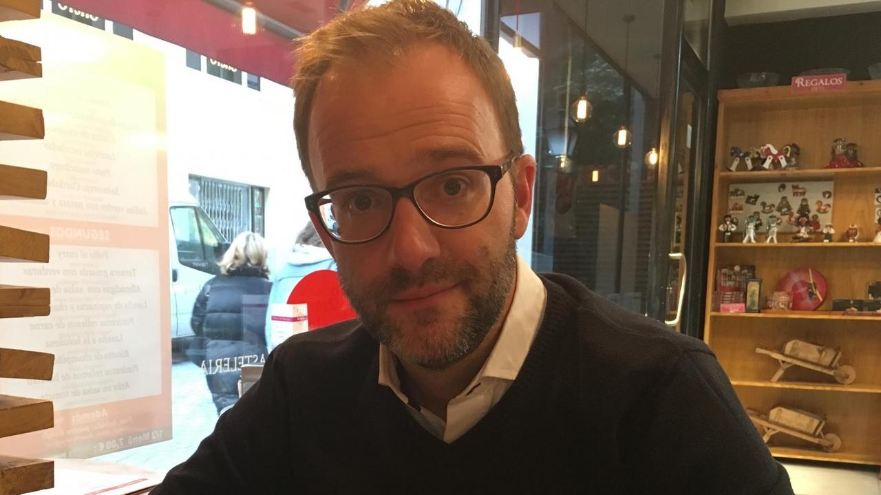 Sid Lowe sitzt an einem Café-Tisch und blickt in die Kamera Sid Lowe sitzt an einem Café-Tisch und blickt in die Kamera