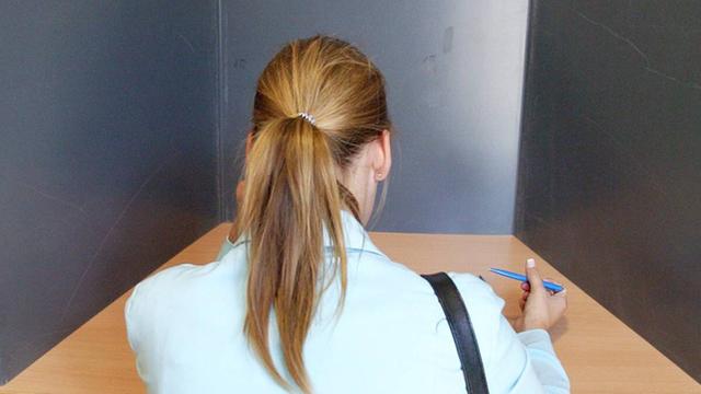Eine junge Wählerin in einer Wahlkabine.