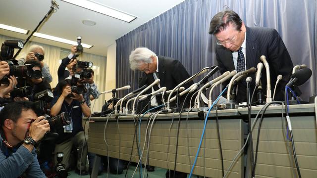 Mitsubishi-Chef Tetsuo Aikawa (r.) und sein Stellvertreter Ryugo Nakao entschuldigen sich für den Manipulationsskandal mit einer in Japan üblichen tiefen Verbeugung.