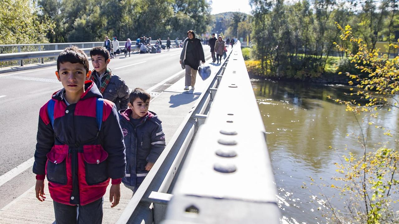 Migranten überqueren am 21.10.2015 den Fluss Mur nahe Spielberg/Österreich, nachdem rund 1.000 Flüchtlinge die Grenze an der Sammelstelle an der slowenisch-österreichischen Grenze durchbrochen hatten. Migranten überqueren am 21.10.2015 den Fluss Mur nahe Spielberg/Österreich, nachdem rund 1.000 Flüchtlinge die Grenze an der Sammelstelle an der slowenisch-österreichischen Grenze durchbrochen hatten.