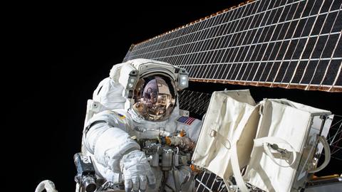 Astronaut im Weltall arbeitet an einer Raumstation