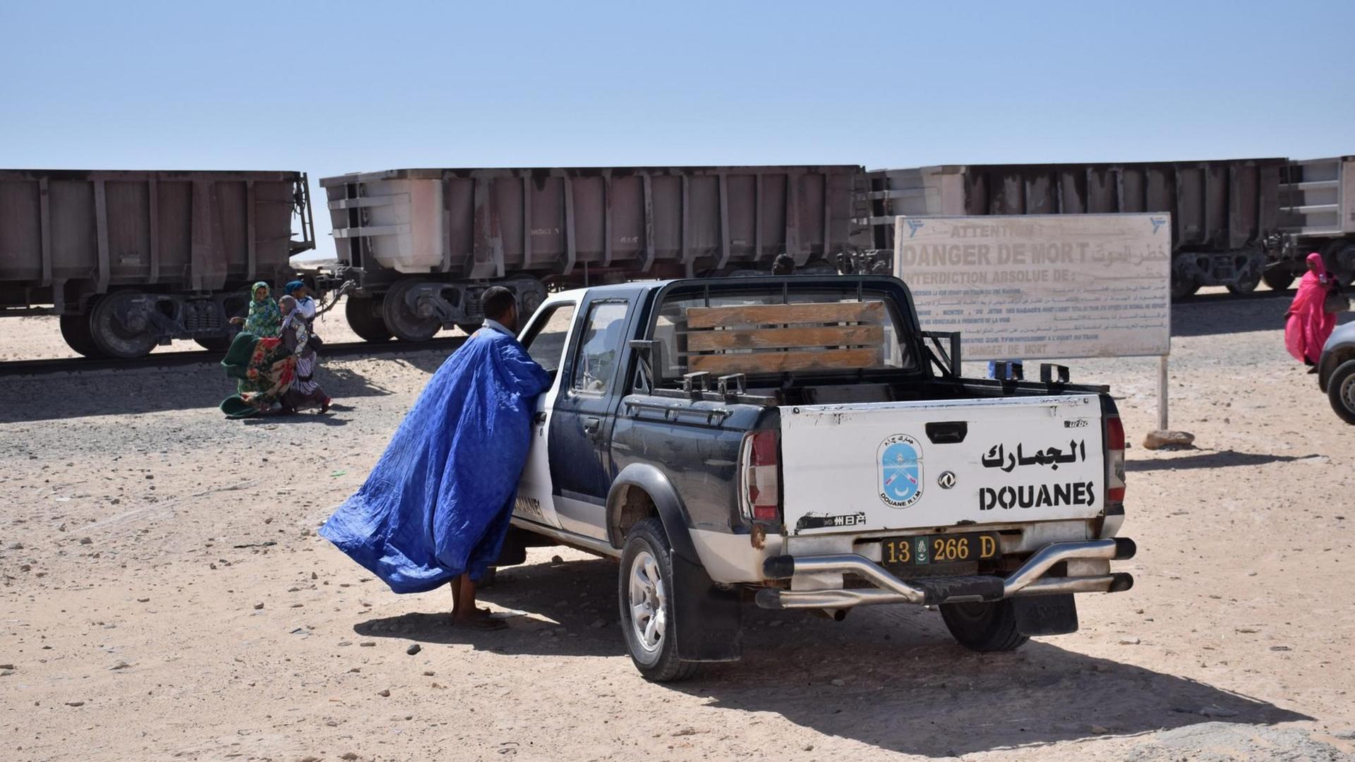 Warten auf den Zug der Erzbahn in Nouadhibou. Die Grenzpolizei überwacht alles, da hinter dem Zug die Westsahara beginnt. Warten auf den Zug der Erzbahn in Nouadhibou. Die Grenzpolizei überwacht alles, da hinter dem Zug die Westsahara beginnt.