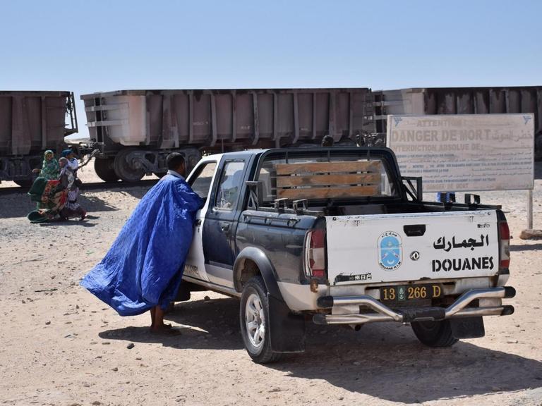 Warten auf den Zug der Erzbahn in Nouadhibou. Die Grenzpolizei überwacht alles, da hinter dem Zug die Westsahara beginnt.