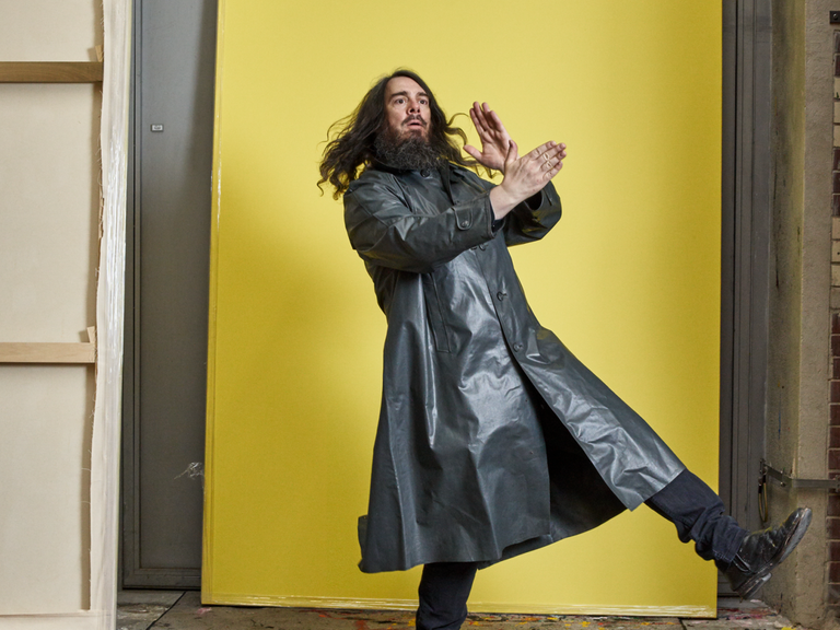 Jonathan Meese in Bewegung zwischen seinen Leinenwänden.
