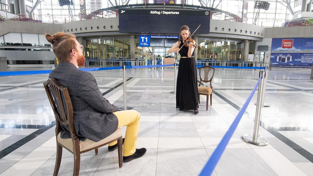 Eine Geigerin spielt für einen einzigen Zuschauer im Flughafen Stuttgart.