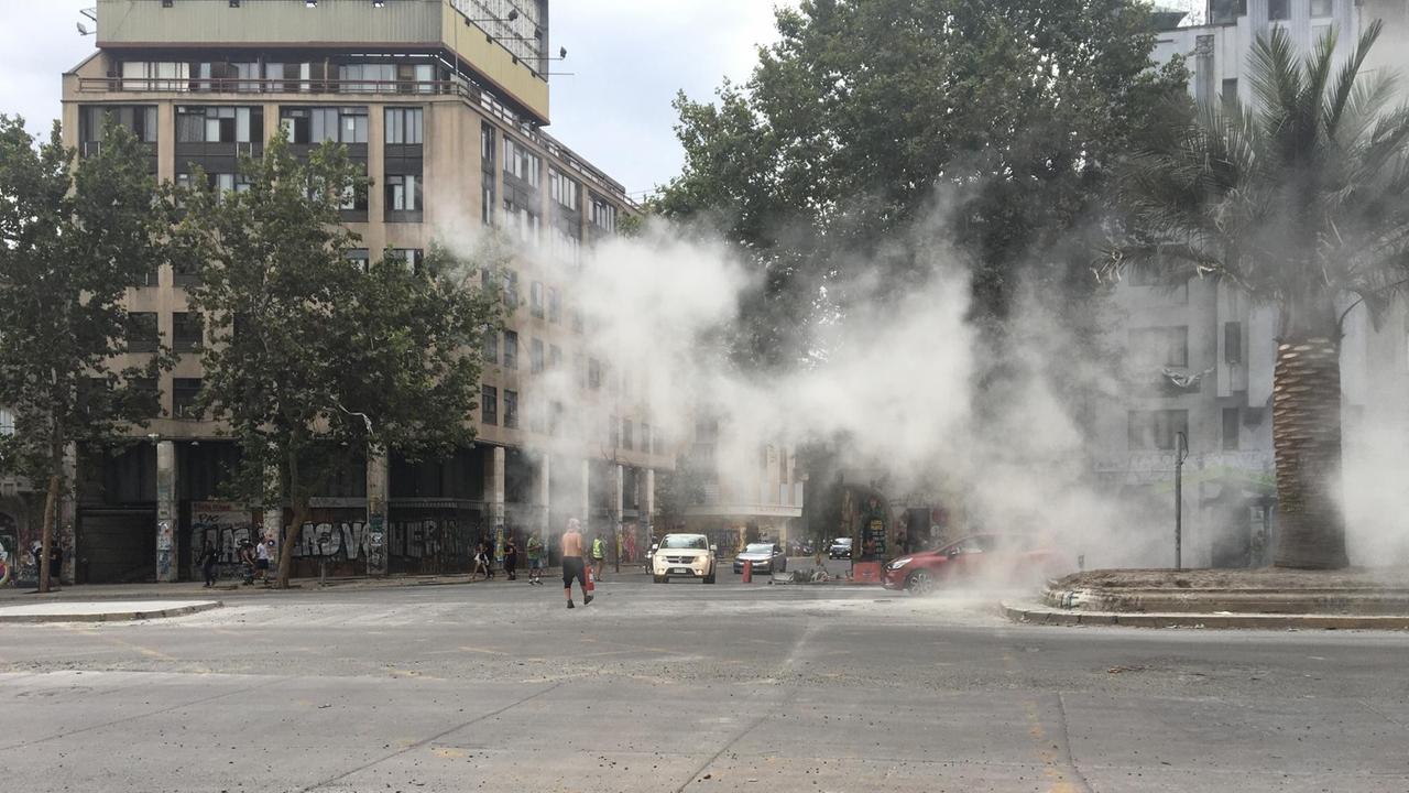 Auf einem Platz in Santiago de Chile sind Rauchwolken zu sehen. 