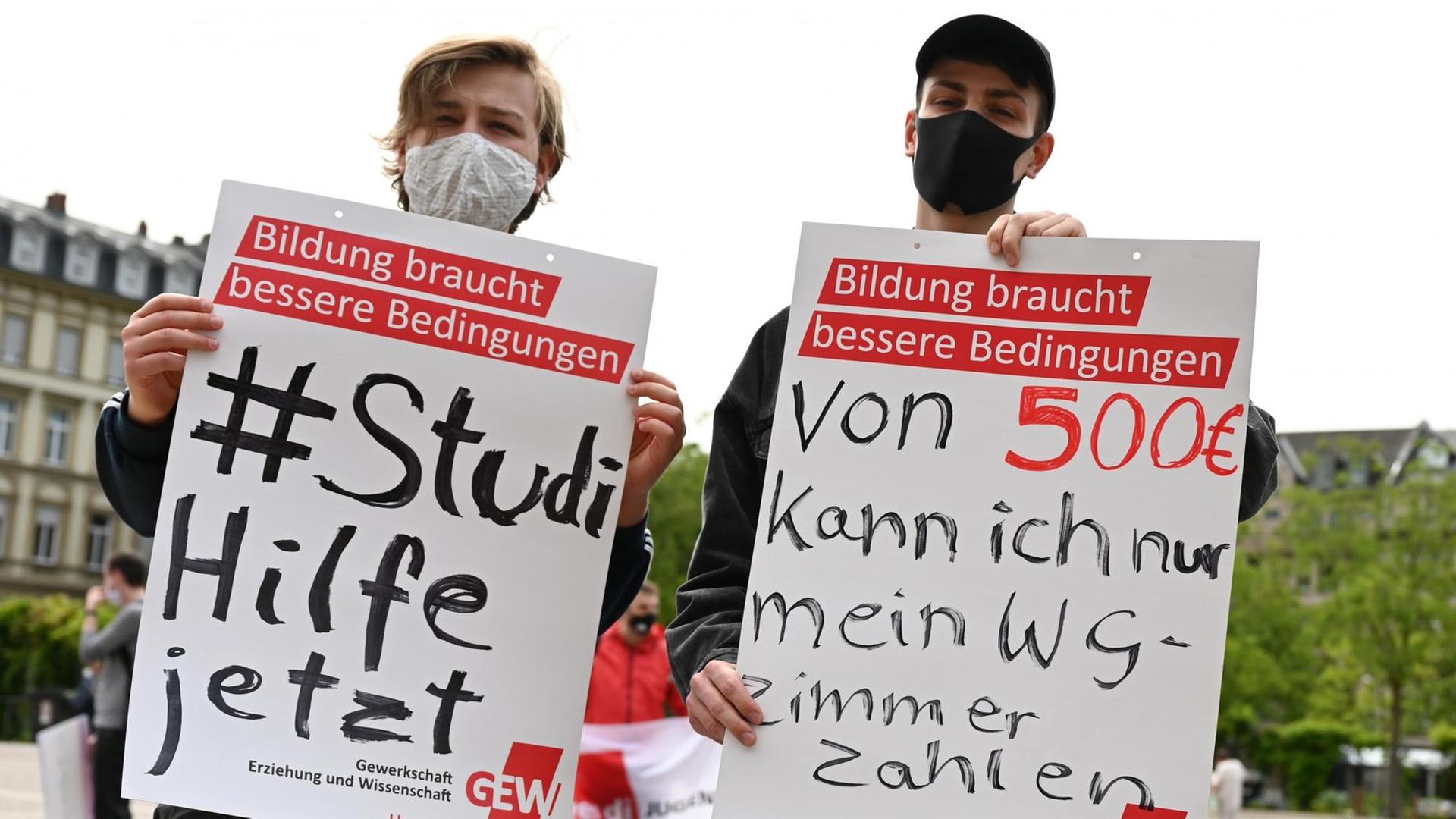 Studenten halten während einer Kundgebung der hessischen Studierendenvertretungen in Wiesbaden Plakate mit der Aufschrift «#StudiHilfejetzt» und «Von 500 Euro kann ich nur mein WG-Zimmer zahlen». Studenten halten während einer Kundgebung der hessischen Studierendenvertretungen in Wiesbaden Plakate mit der Aufschrift «#StudiHilfejetzt» und «Von 500 Euro kann ich nur mein WG-Zimmer zahlen».