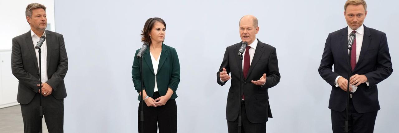 Wichtige Personen von den 3 Parteien stehen bei einer Presse-Konferenz an Mikrofonen. Wichtige Personen von den 3 Parteien stehen bei einer Presse-Konferenz an Mikrofonen.