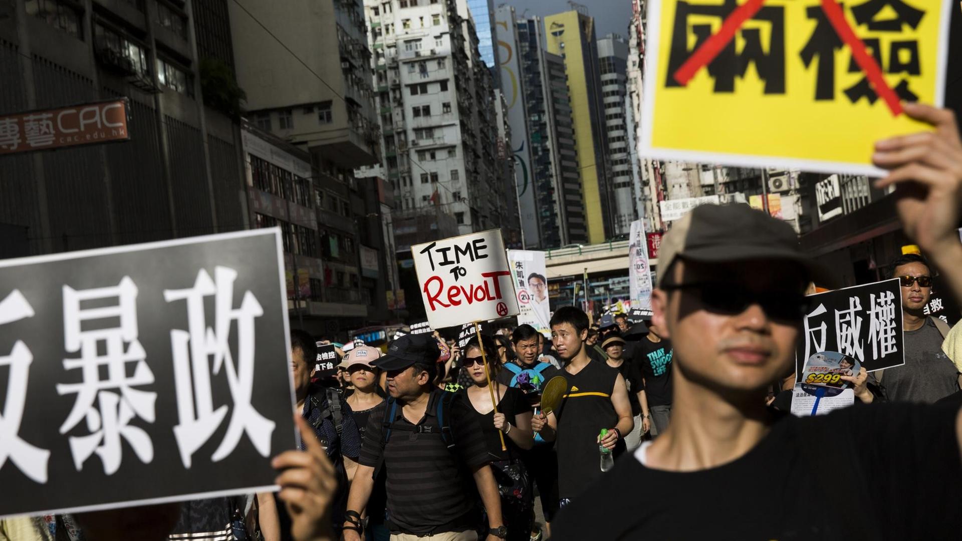 Demonstranten halten Schilder mit chinesischen Schriftzeichen hoch. Demonstranten halten Schilder mit chinesischen Schriftzeichen hoch.