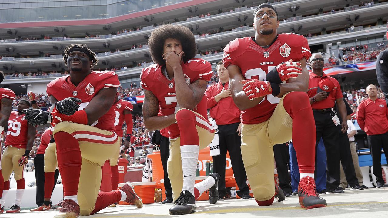 Vor einem Spiel gegen die Dallas Cowboys knien Eli Harold, Colin Kaepernick und Eric Reid (v.l.) während der Nationalhymne, um gegen Rassismus zu protestieren (2.10.2016). 
