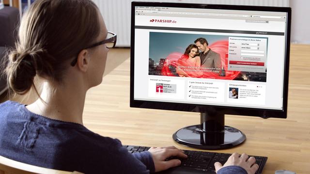 Frau sitzt am Computer, surft im Internet in einem Onlinedating-Portal