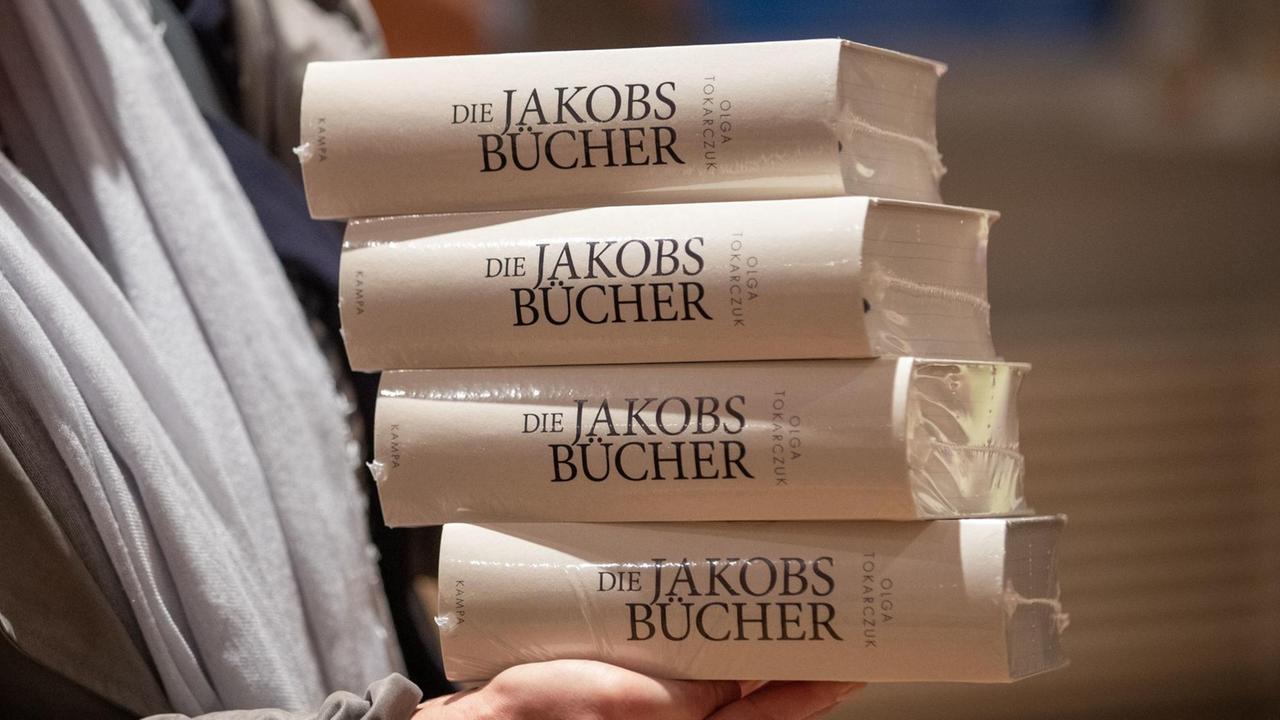Das letzte Werk "Die Jakobsbücher" der polnischen Autorin Olga Tokarczuk in mehreren Ausgaben auf einem Stapel. Das letzte Werk "Die Jakobsbücher" der polnischen Autorin Olga Tokarczuk in mehreren Ausgaben auf einem Stapel.