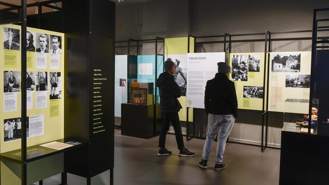 Zwei Personen schauen sich die Ausstellung mit Informationstafeln in der Gedenkstätte Deutscher Widerstand in Berlin an.