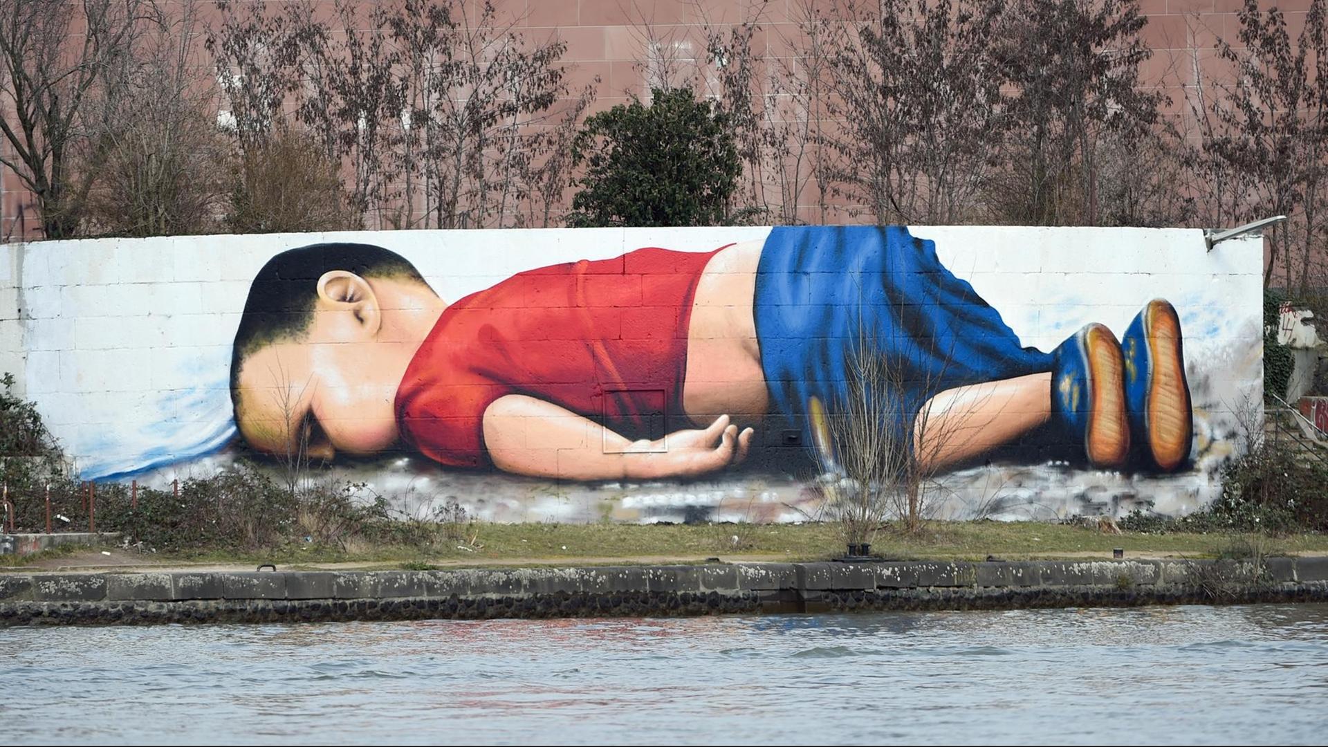 Das ertrunkene syrische Flüchtlingskind Aylan Kurdi auf einem Graffito der Künstler Justus Becker und Oguz Sen in Frankfurt Das ertrunkene syrische Flüchtlingskind Aylan Kurdi auf einem Graffito der Künstler Justus Becker und Oguz Sen in Frankfurt