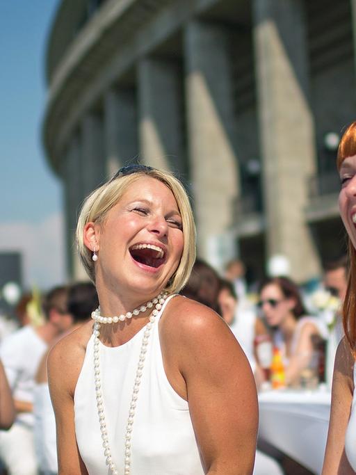 Weiß gekleidete Menschen treffen sich am 26.07.2014 zum "White Dinner" (Weißes Essen) am Olympiastadion in Berlin. Bei diesem Picknick unter freien Himmel sind alle Gäste weiß gekleidet.