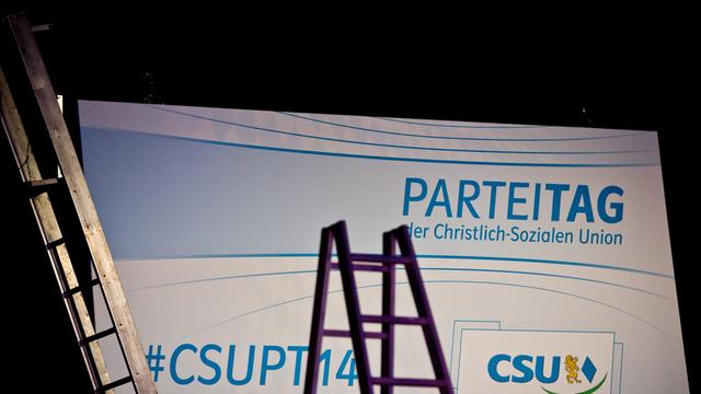 Bild vom Aufbau des CSU-Parteitags in Nürnberg: Zwei Leitern stehen vor einer beleuchteten Leinwand mit dem CSU-Logo.