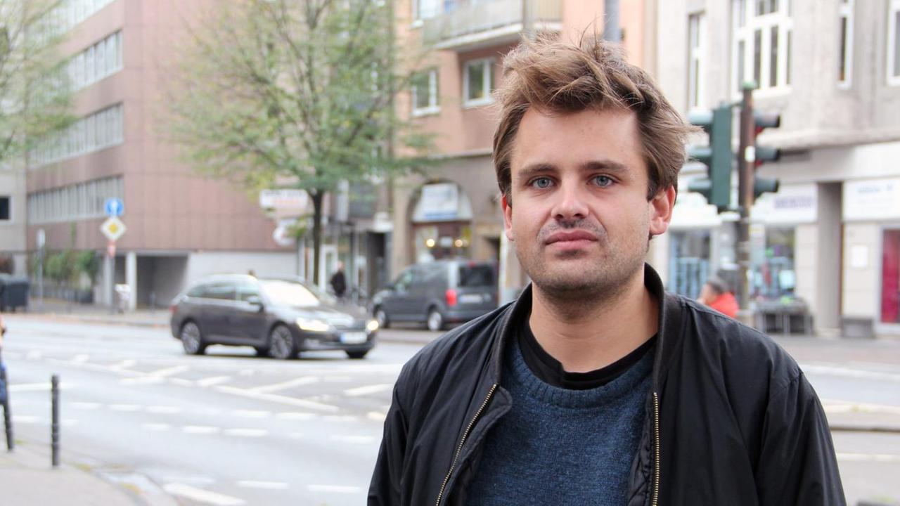 Der Regisseur und Dramaturg Julian Pörksen steht an einer Straße in Köln Der Regisseur und Dramaturg Julian Pörksen steht an einer Straße in Köln