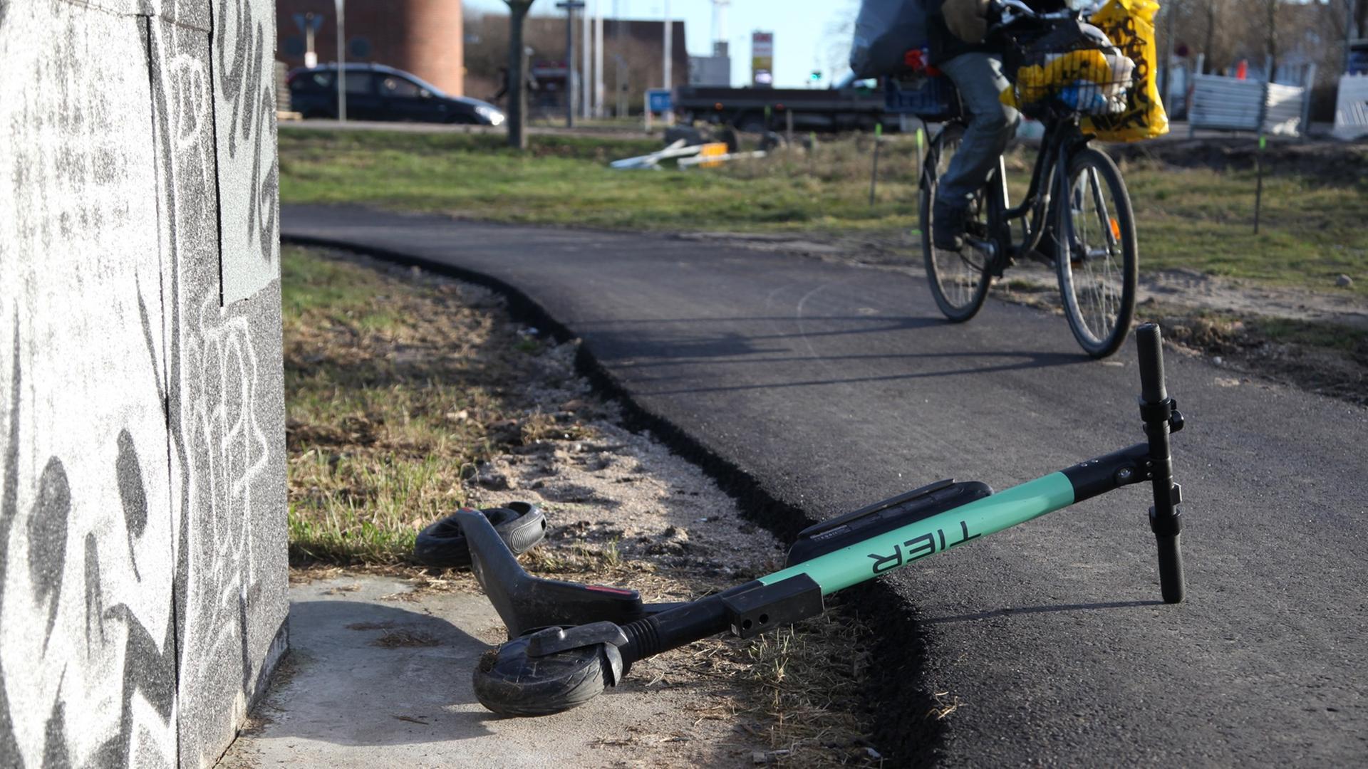 Ein Radfahrer weicht auf einem Radweg in Kopenhagen einem umgekippten E-Scooter aus.