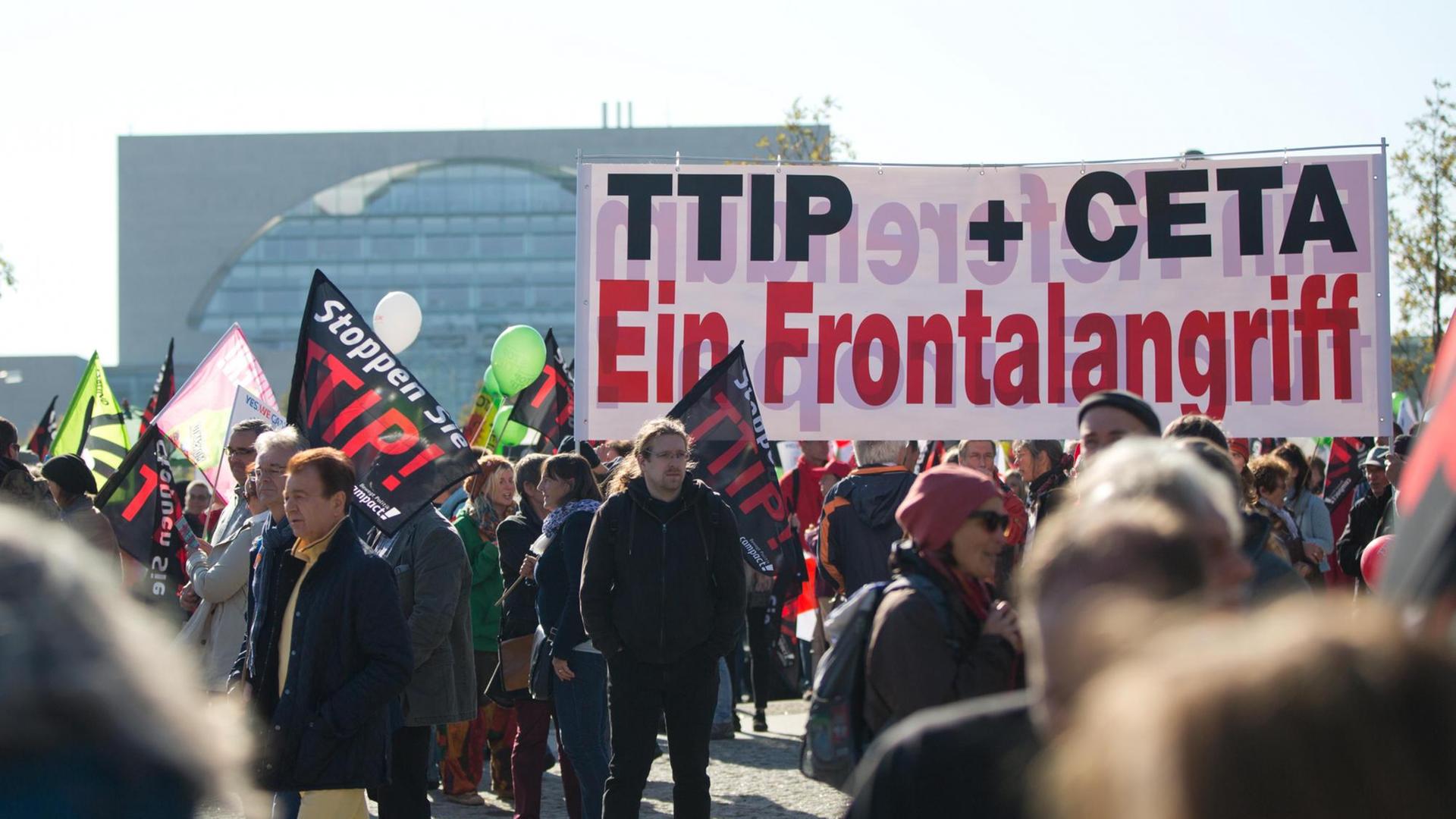 Ein Transparent mit der Aufschrift "TTIP + CETA Ein Frontalangriff" ist bei einer Demonstration gegen das transatlantische Handelsabkommen TTIP (USA) und Ceta (Kanada) am 10.10.2015 in Berlin zu sehen. Ein Transparent mit der Aufschrift "TTIP + CETA Ein Frontalangriff" ist bei einer Demonstration gegen das transatlantische Handelsabkommen TTIP (USA) und Ceta (Kanada) am 10.10.2015 in Berlin zu sehen.