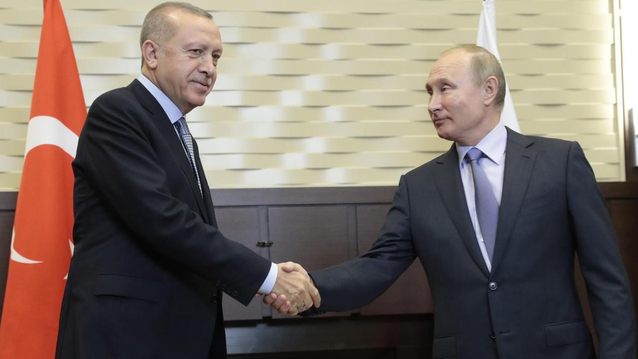 Der türkische Präsident Erdogan und der russische Präsident Putin reichen sich die Hand.