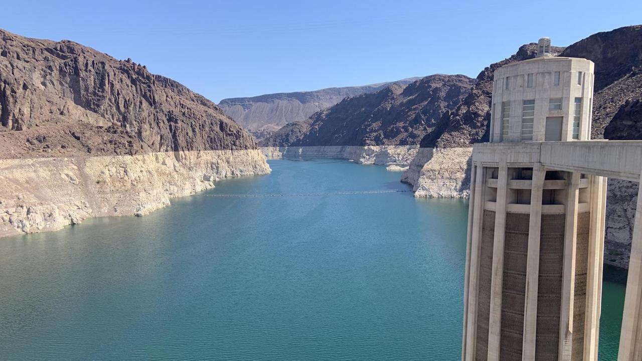Ein großer See mit türkisfarbenem Wasser umgeben von Felsen, die deutliche Ränder im oberen Bereich zeigen. Ein großer See mit türkisfarbenem Wasser umgeben von Felsen, die deutliche Ränder im oberen Bereich zeigen.