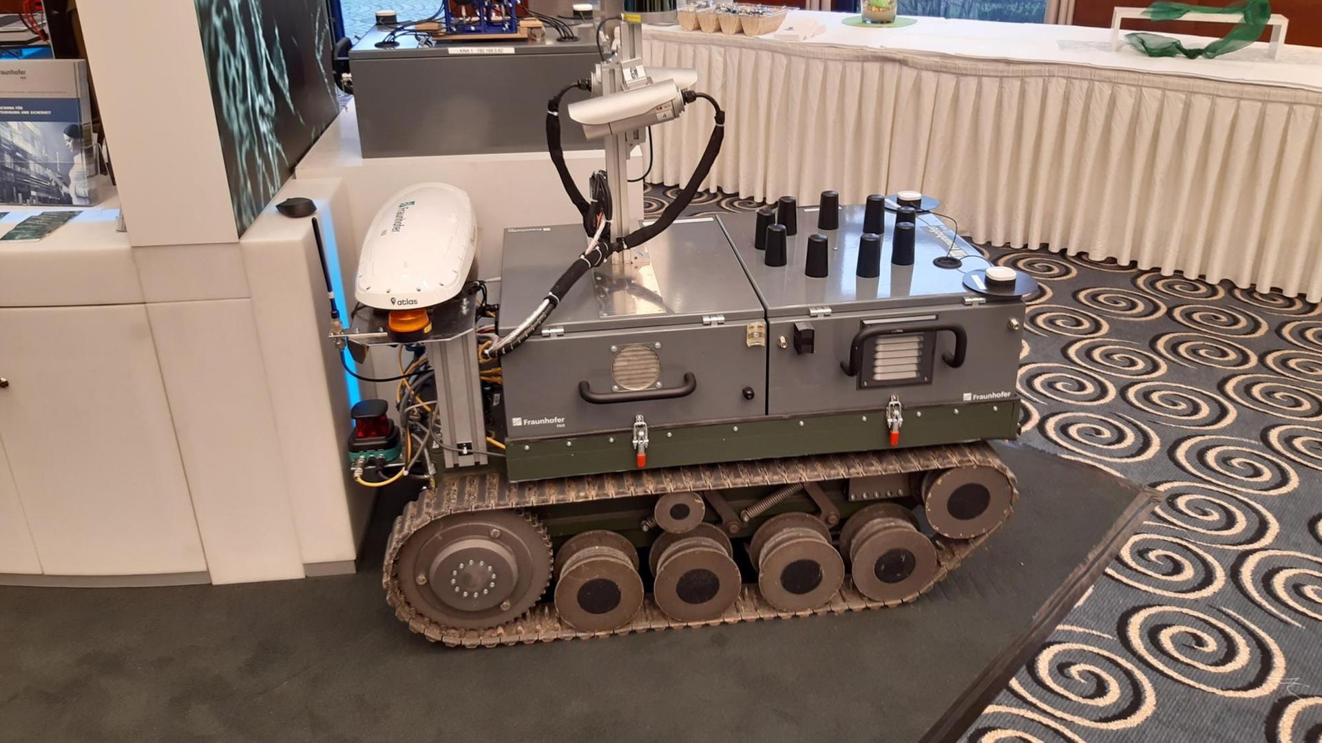 "Theodor" wird dieser Bodenroboter von den Mitarbeitern des Fraunhofer-Instituts genannt. Schießen kann er nicht, aber Überwachen und Aufklären: Von der Handy-Ortung bis hin zur Schuss-Detektion. Ein Mosaikstein in unbemannten, vernetzten Waffensystemen, die künftig mit Hilfe von Algorithmen auch selber Entscheidungen über Leben und Tod treffen könnten. "Theodor" wird dieser Bodenroboter von den Mitarbeitern des Fraunhofer-Instituts genannt. Schießen kann er nicht, aber Überwachen und Aufklären: Von der Handy-Ortung bis hin zur Schuss-Detektion. Ein Mosaikstein in unbemannten, vernetzten Waffensystemen, die künftig mit Hilfe von Algorithmen auch selber Entscheidungen über Leben und Tod treffen könnten.