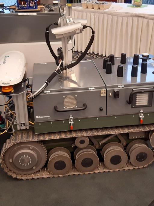 "Theodor" wird dieser Bodenroboter von den Mitarbeitern des Fraunhofer-Instituts genannt. Schießen kann er nicht, aber Überwachen und Aufklären: Von der Handy-Ortung bis hin zur Schuss-Detektion. Ein Mosaikstein in unbemannten, vernetzten Waffensystemen, die künftig mit Hilfe von Algorithmen auch selber Entscheidungen über Leben und Tod treffen könnten.
