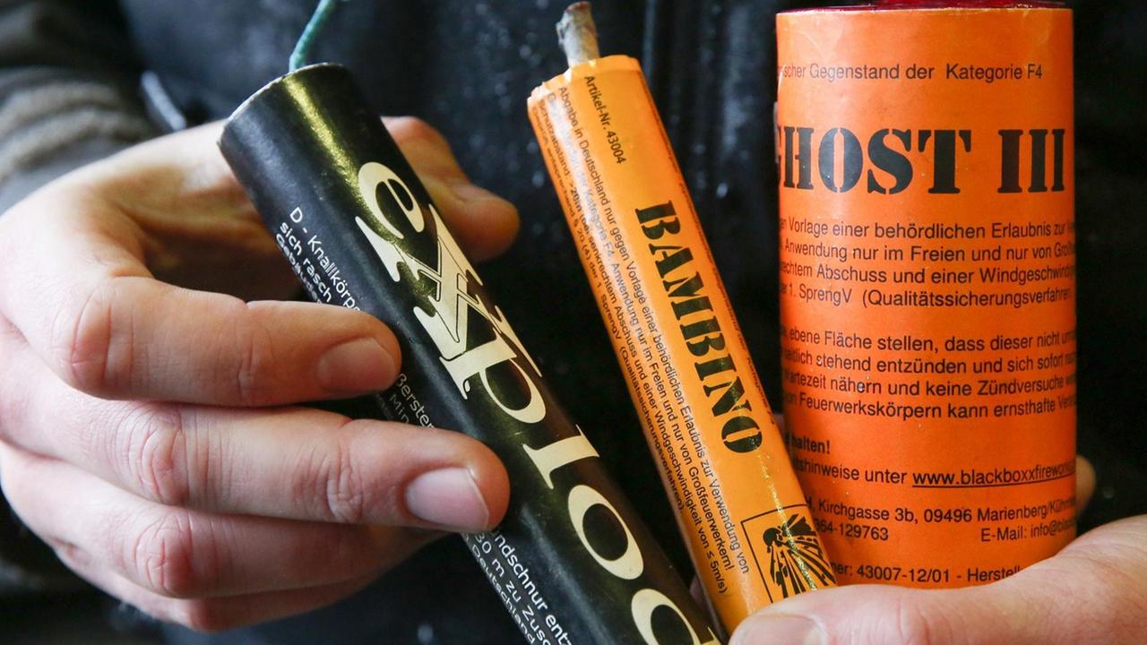 Ein Feuerwerker zeigt am 19.12.2014 bei einem Pressetermin in der Feuerwehrakademie in Hamburg zwei Böller der Kategorie F4 (orange Farbe) und einen in Deutschland nicht zugelassenen Böller (schwarze Farbe). Ein Feuerwerker zeigt am 19.12.2014 bei einem Pressetermin in der Feuerwehrakademie in Hamburg zwei Böller der Kategorie F4 (orange Farbe) und einen in Deutschland nicht zugelassenen Böller (schwarze Farbe).