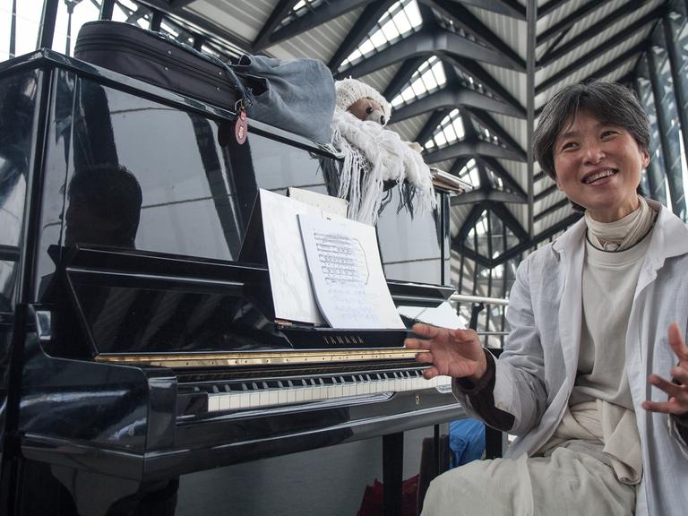 Die Künstlerin Nobuyo am Klavier im Flughafen Lyon - sie ist vor einem Jahr hier gestrandet