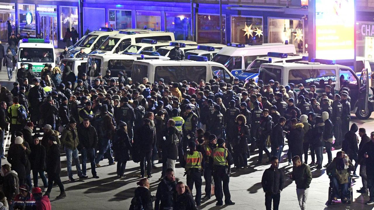Polizisten umringen am 31.12.2016 vor dem Hauptbahnhof in Köln eine Gruppe südländisch aussehender Männer. 