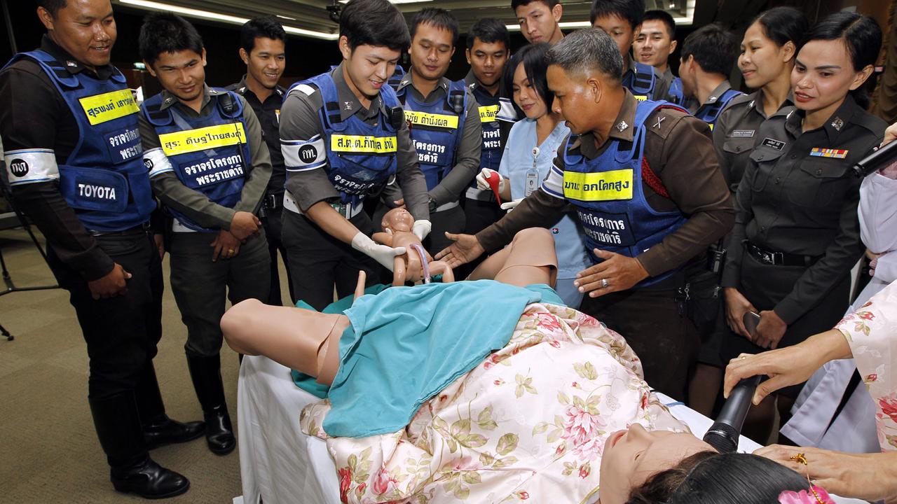 Thailändische Verkehrspolizisten bei einer Geburtsübung in Bangkok. Wegen notorischer Dauerstaus mussten schon zahlreiche Frauen im Auto gebären. Thailändische Verkehrspolizisten bei einer Geburtsübung in Bangkok. Wegen notorischer Dauerstaus mussten schon zahlreiche Frauen im Auto gebären.