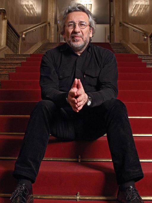 Can Dündar im Maxim Gorki Theater auf einer roten Treppe.
