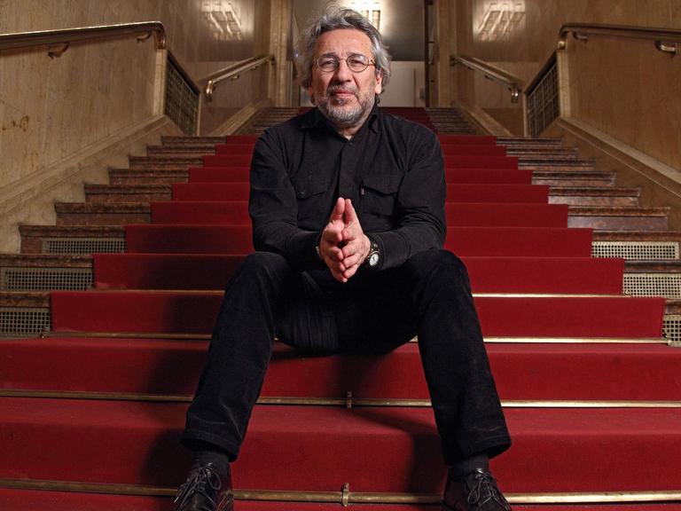 Can Dündar im Maxim Gorki Theater auf einer roten Treppe.