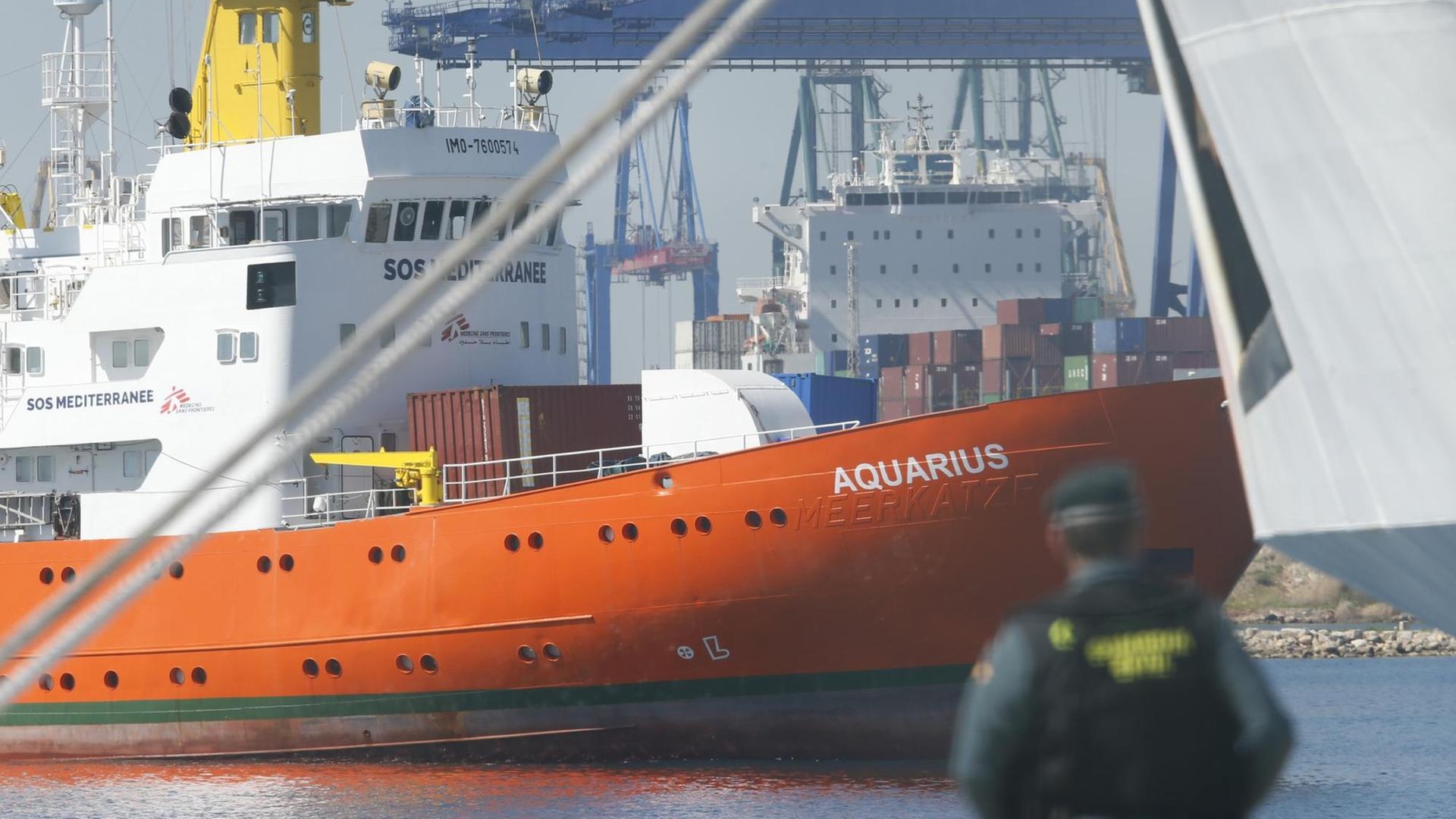 Ein Mann mit Uniform steht im Hafen von Valencia und blickt auf das Schiff "Aquarius"