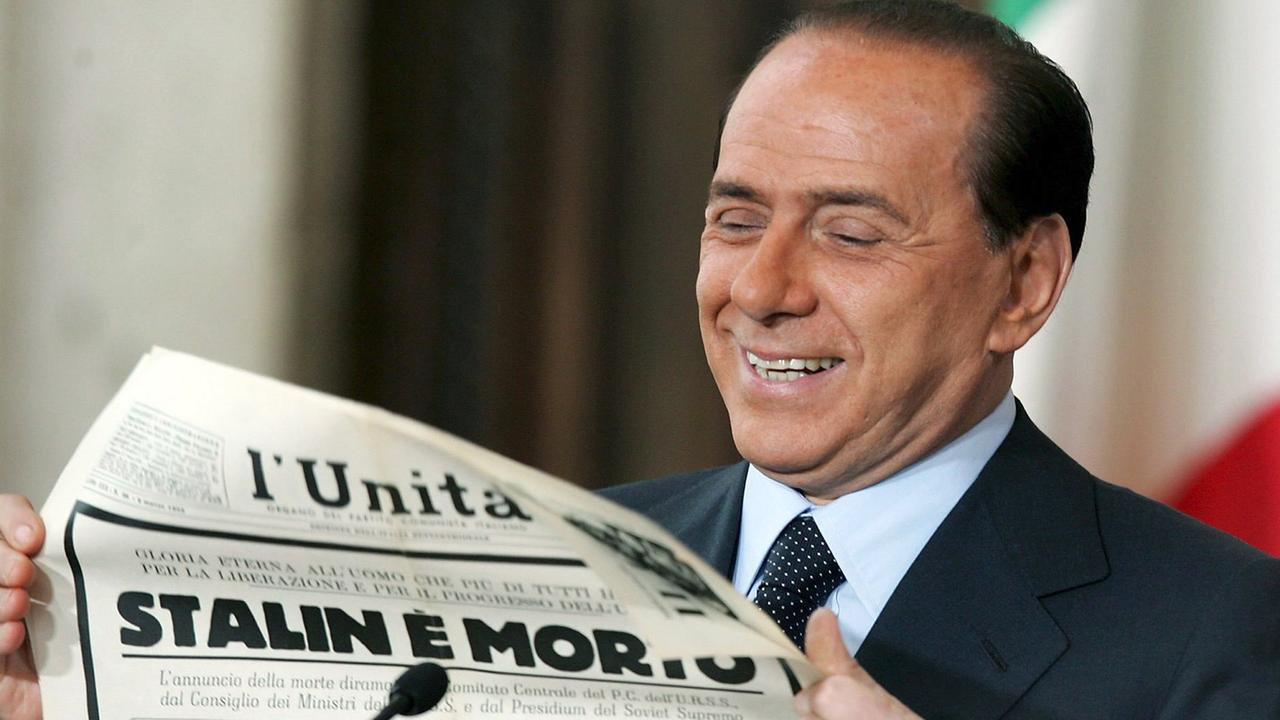 Der italienische Ministerpräsident Silvio Berlusconi lächelt, als er in der Villa Madama in Rom eine«L'Unita»-Ausgabe aus dem Jahr 1953 mit Lobeshymnen auf den toten Sowjet-Diktator Stalin hochhält. Der italienische Ministerpräsident Silvio Berlusconi lächelt, als er in der Villa Madama in Rom eine«L'Unita»-Ausgabe aus dem Jahr 1953 mit Lobeshymnen auf den toten Sowjet-Diktator Stalin hochhält.