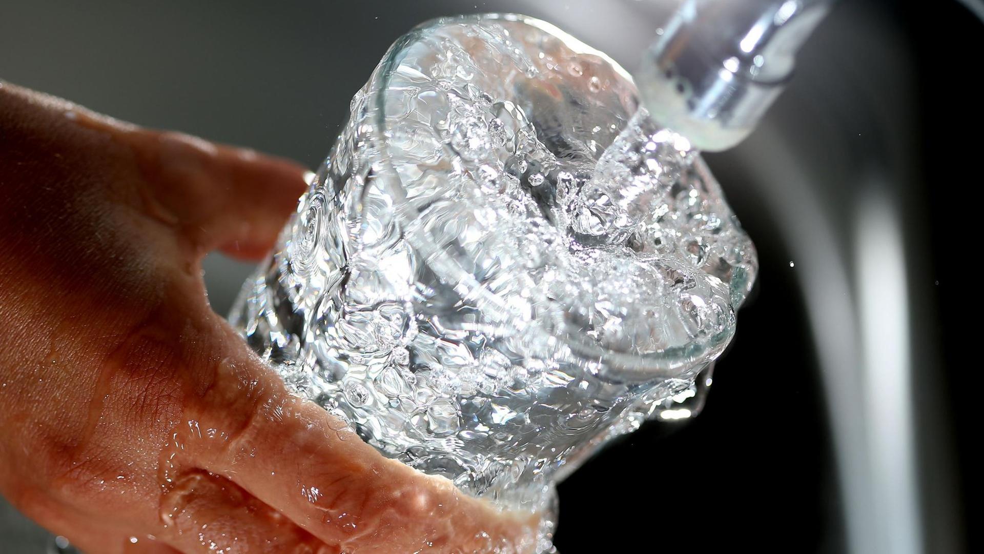 Trinkwasser läuft in ein Glas. Trinkwasser läuft in ein Glas.