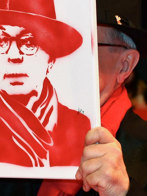 Abschluss der 69. Berlinale: Der scheidende langjährige Festivaldirektor Dieter Kosslick zeigt sich am roten Teppich mit einem Portrait von sich - natürlich ganz in rot