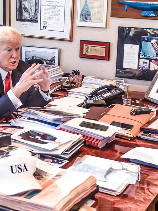 Donald Trump vor seinem vollgestellten Schreibtisch, dahinter Kai Diekmann.