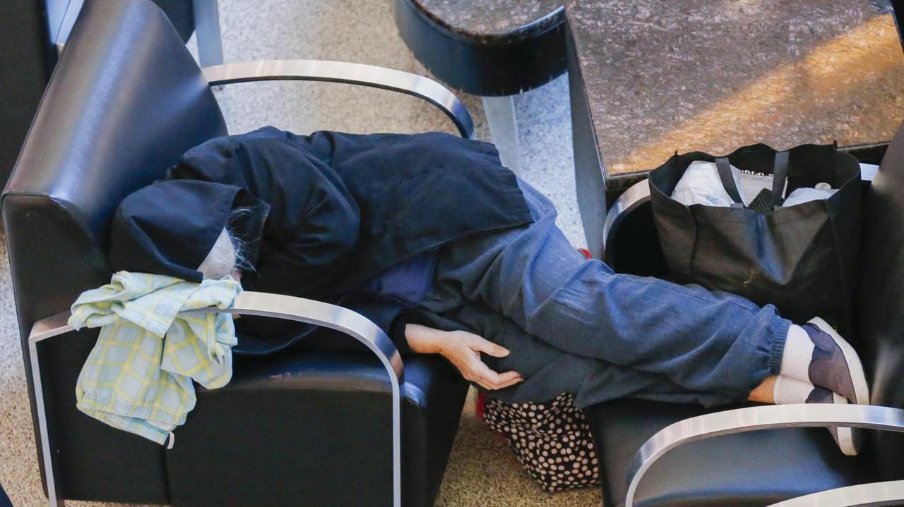 Flughafen in Atlanta, USA. Ein Passagier schläft in der Abfertigungshalle.