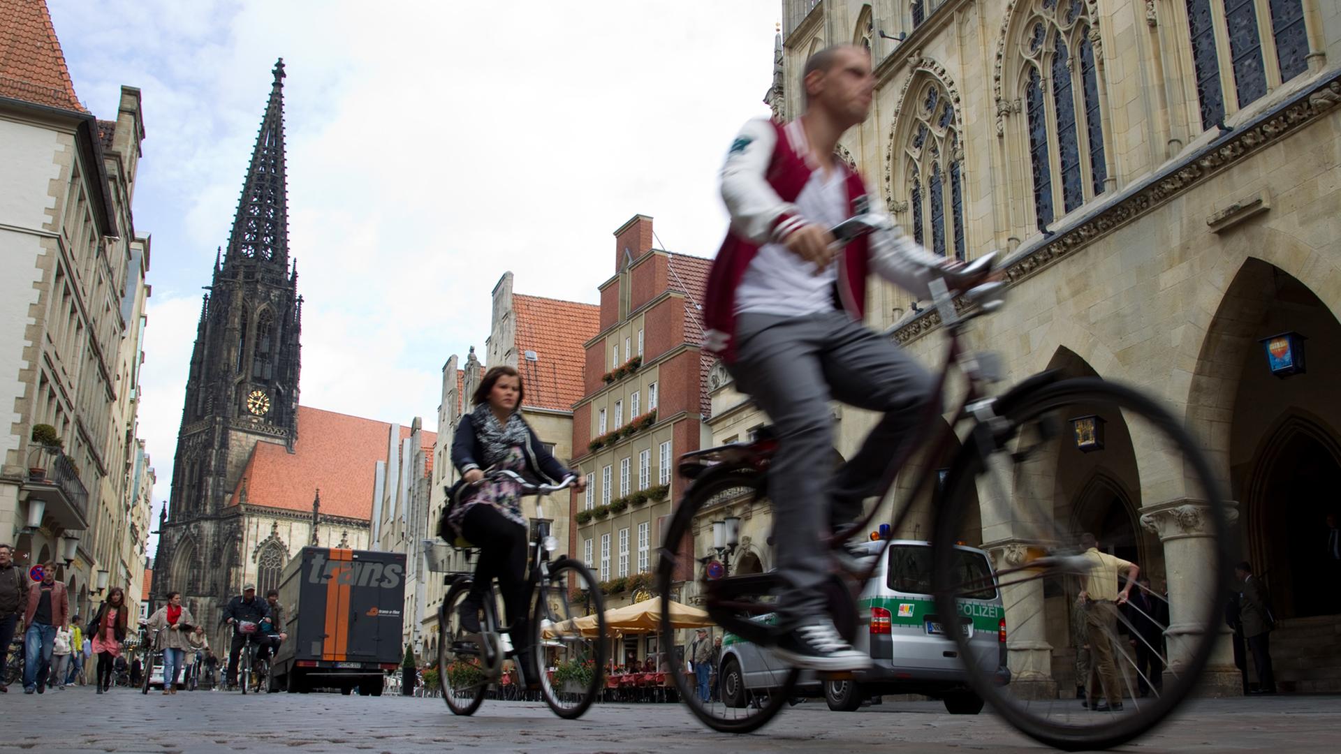 Radfahrer in der Altstadt von Münster. Im Hintergrund die Lambertikirche. Radfahrer in der Altstadt von Münster. Im Hintergrund die Lambertikirche.