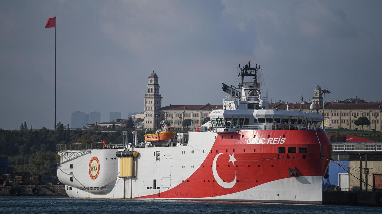 Ein großes weiß-rotes Schiff mit türkischem Stern und Sichel liegt im Hafen.