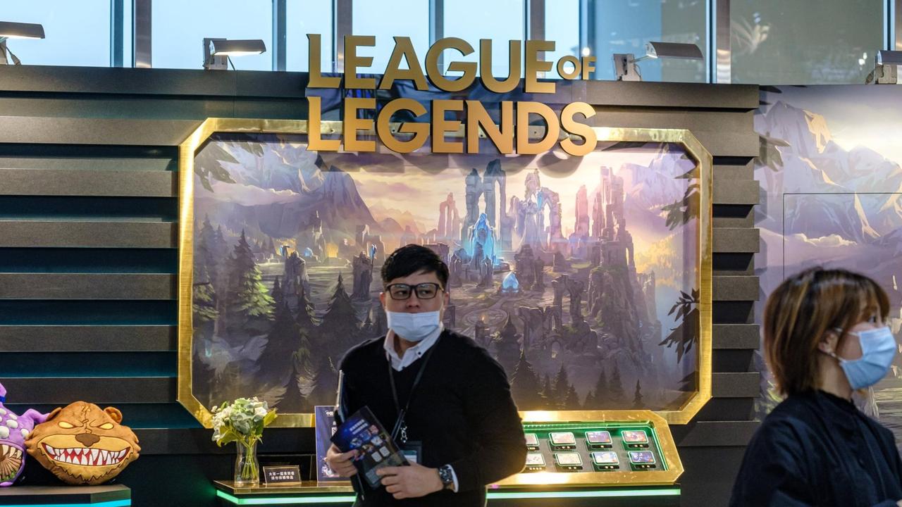 Ein Messebesucher mit Mund-Nasenschutz vor einem "League-of-Legends"-Schild. Ein Messebesucher mit Mund-Nasenschutz vor einem "League-of-Legends"-Schild.