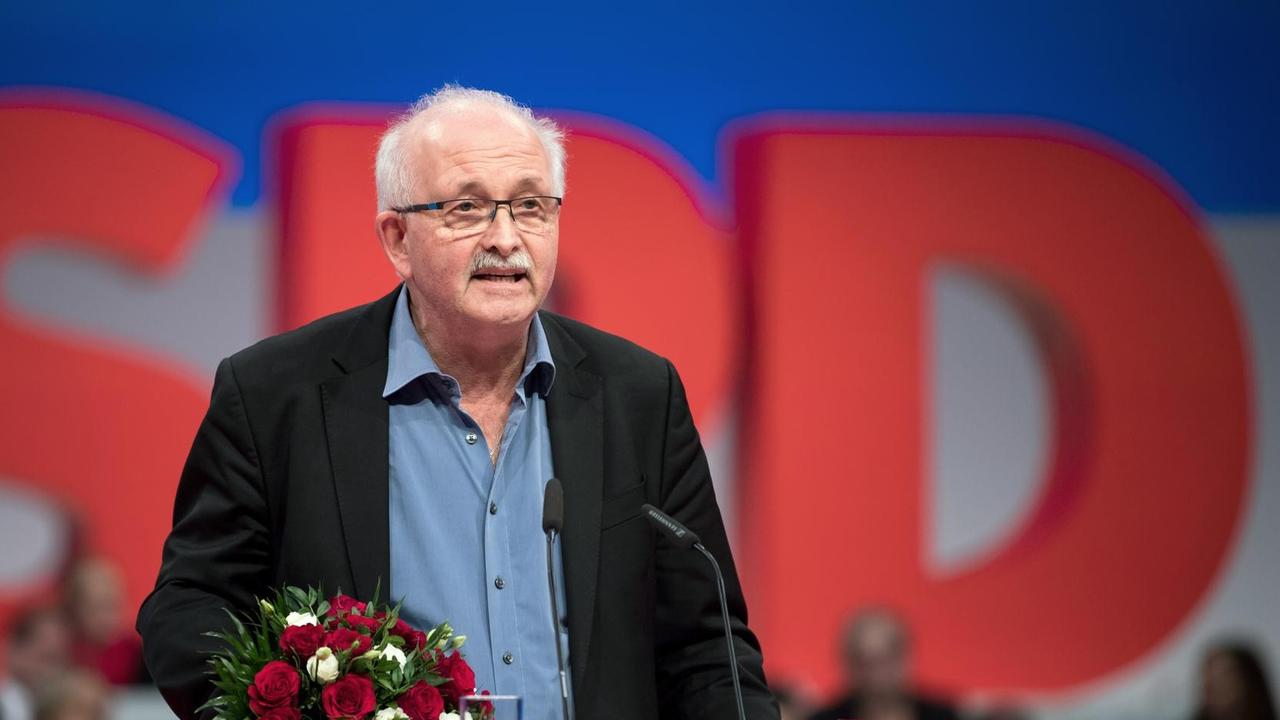 Udo Bullmann (SPD) an einem Rednerpult der SPD. Er hat Blumen in der Hand. Udo Bullmann (SPD) an einem Rednerpult der SPD. Er hat Blumen in der Hand.