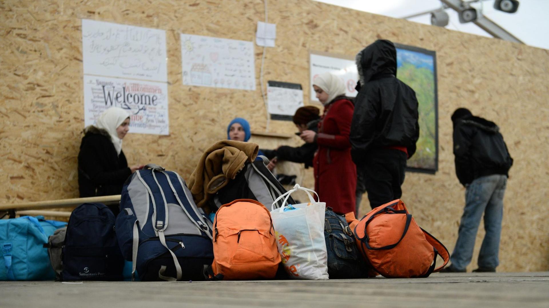 Syrische Flüchtlinge sitzen am 31.01.2016 im Wartezentrum für Flüchtlinge beim Fliegerhorst in Erding (Bayern) und warten auf ihre Registrierung Syrische Flüchtlinge sitzen am 31.01.2016 im Wartezentrum für Flüchtlinge beim Fliegerhorst in Erding (Bayern) und warten auf ihre Registrierung