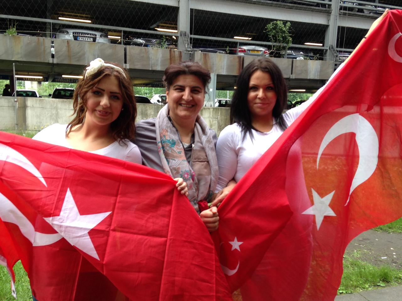 Drei Frauen halten türkische Flaggen hoch Drei Frauen halten türkische Flaggen hoch