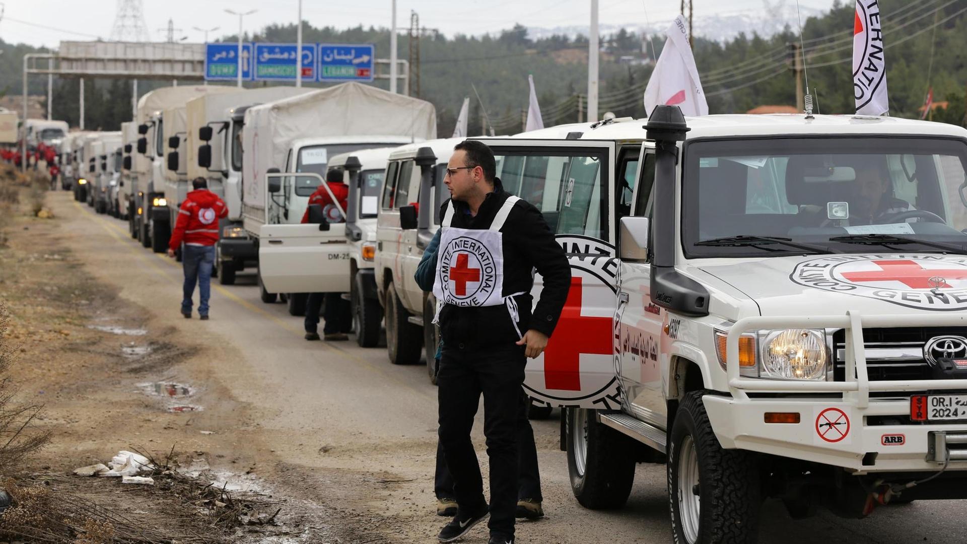 Fahrzeuge des Hilfskonvois am Rande der belagerten syrischen Stadt Madaja.