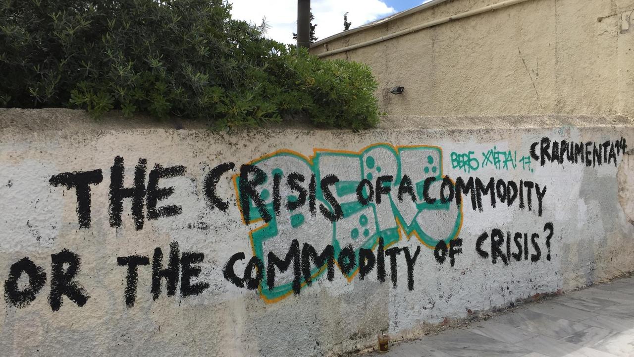 "The crisis of a commodity or the commodity of the crisis" und "crapumenta 14" steht mit schwarzer Farbe auf einer Mauer in Athen geschrieben. "The crisis of a commodity or the commodity of the crisis" und "crapumenta 14" steht mit schwarzer Farbe auf einer Mauer in Athen geschrieben.