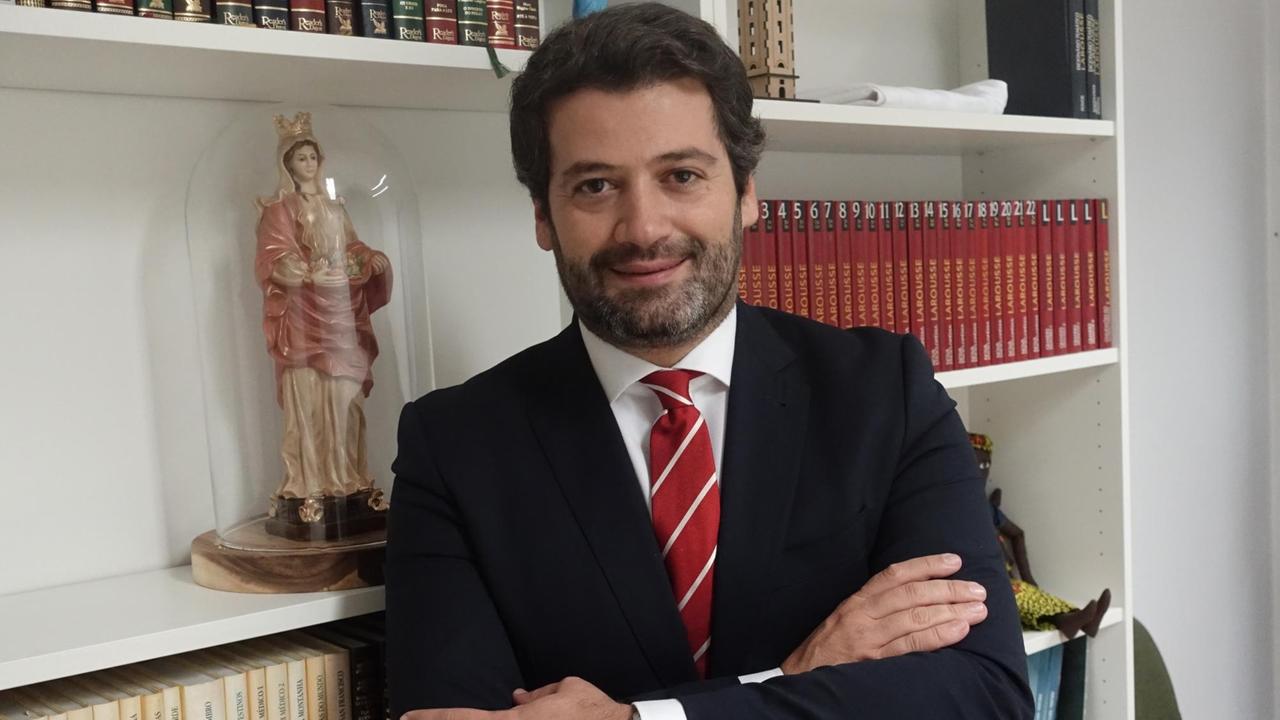 Ein lächelnder Mann mit dunklem Vollbart und roter Krawatte und verschränkten Armen. Ein lächelnder Mann mit dunklem Vollbart und roter Krawatte und verschränkten Armen.