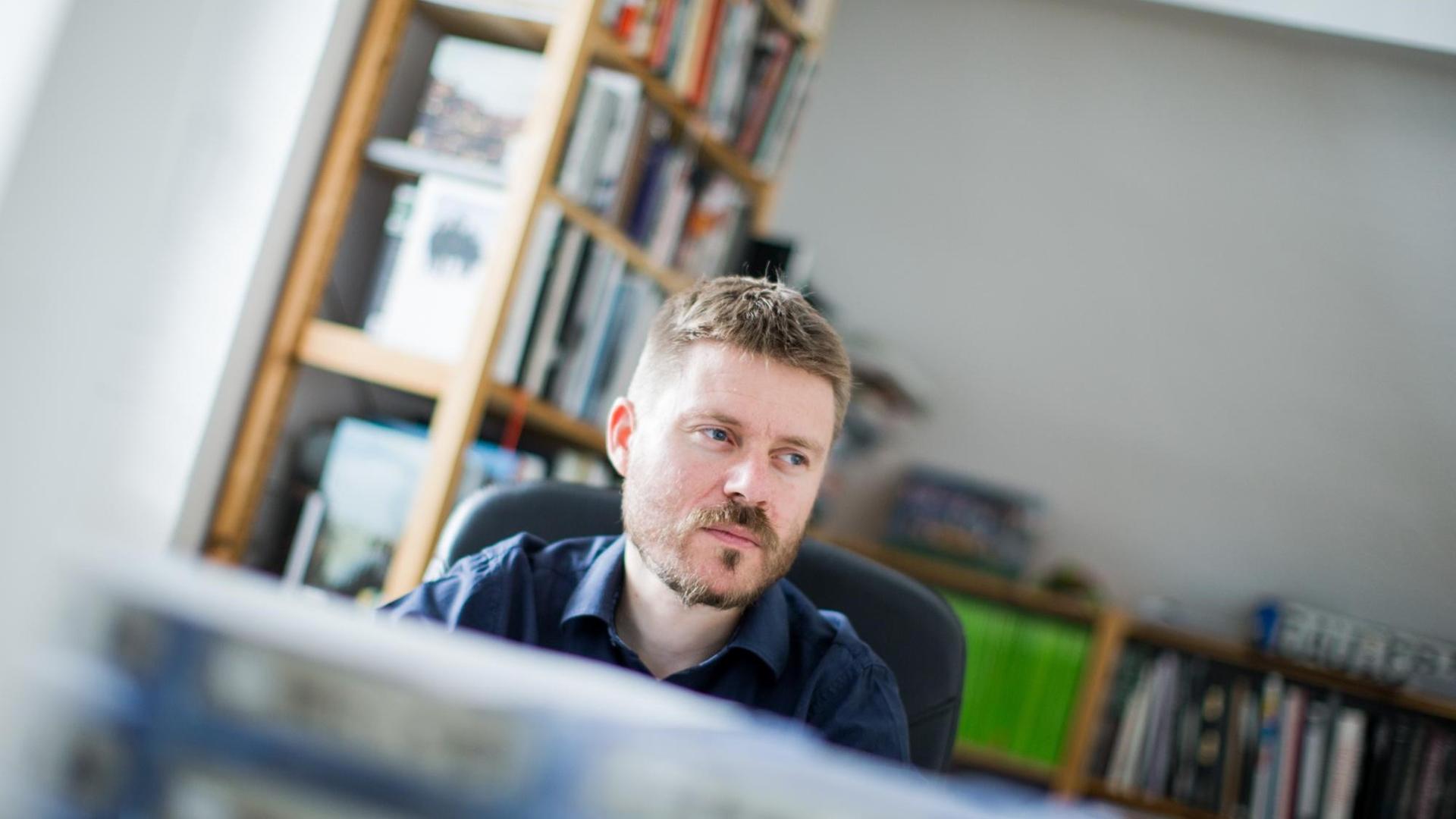 Ein Porträt des Fotojournalisten Christoph Bangert am Schreibtisch in einem Arbeitszimmer. Ein Porträt des Fotojournalisten Christoph Bangert am Schreibtisch in einem Arbeitszimmer.